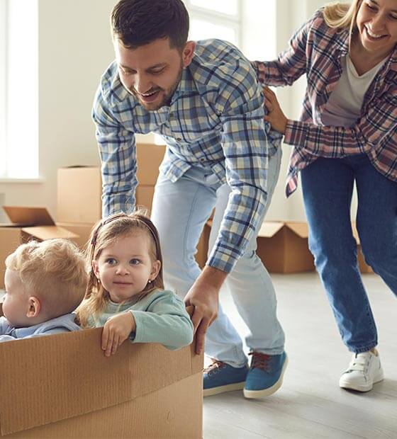 woman and 2 children packing up boxes to move house